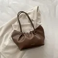 Dark brown faux leather shoulder bag with cloud-style pleated design and gold lettering - Brown