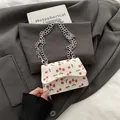Mini Schultertasche mit Kirschmuster und Silberkette auf grauem Sakko-Hintergrund - Kirschweiß