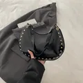Glänzende schwarze Halbmond-Schultertasche mit goldenen Nieten und Lackleder-Oberfläche - Schwarz