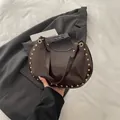 Dunkelbraune Schultertasche aus glänzendem Lackleder mit goldenen Nieten und Metall - Braun