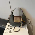 Sac hobo croissant en daim gris foncé et cuir marron avec pompon en perles de bois - Avec Pendentif / Gris