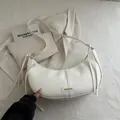 Elegant white crescent shoulder bag in matte faux leather with metal buckle and fringe detail - White