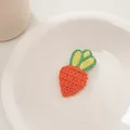 Close-up of handmade crochet carrot hair clip with detailed orange and green knit texture - Orange Carrot