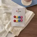 Detailed view of colorful floral hair clips with sparkling rhinestones on display card - 4 Little Flowers Style