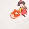Detail view of handmade crochet flower hair tie with orange petals and pink center - Orange