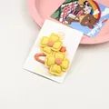 Vue détaillée de deux barrettes à fleurs en tissu fait main avec pétales jaunes et rose - Jaune