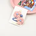 Détail de pinces à cheveux fleurs en tissu rose avec broderie sur une carte de vente - Rose