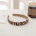 Detalle de una diadema fina con estampado de cebra y forro de terciopelo marrón suave - Diadema / Cebra Café