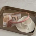 Dettaglio del cerchietto rosa satinato con fodera antiscivolo e bordi rifiniti - Rosa Crema