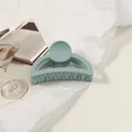 Détail d'une pince à cheveux vert sauge mat sur un fond blanc esthétique épuré - Bleu Lait