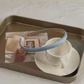 Detailed view of light blue faux leather headband on a vintage tray - Creamy Blue