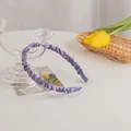 Close-up of purple satin pleated headband with elegant scrunchie texture in a lifestyle setting - Grape Purple
