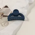 Detailed close-up of matte dark blue shark clip hair claw on aesthetic paper and glass - Navy Blue