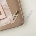 Detailansicht der Haarspange aus weißem Marmorharz mit goldener Metall-Entenschnabelklemme - Perlmuttweiß
