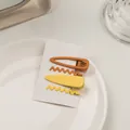 Detalle de set de 4 horquillas mate en color amarillo y naranja sobre una tarjeta - Serie Amarilla