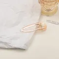 Nahaufnahme einer champagnerfarbenen Haarklammer aus Acryl mit hohlem Wassertropfen-Design - Groß / Transparentes Rosa