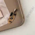 Nahaufnahme der Haarspange mit Schildpattmuster und goldenem Metall-Entenschnabelclip - Helles Leopardenmuster