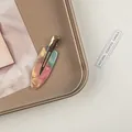 Nahaufnahme der rosa-grünen Acetat-Haarklammer auf einem Vintage-Bronze-Metalltablett - Grün Rosa