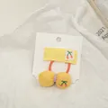 Détail d'un chouchou jaune avec broderie cerise sur une carte de présentation - Jaune