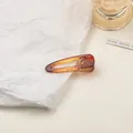 Close-up of amber translucent triangular hair clip with internal teeth for strong grip - Small / Tortoise