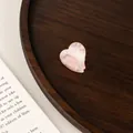 Macro detail of a mini pink heart claw clip with premium marble acetate texture finish - Sakura Pink