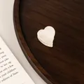 Macro detail of a pearl white heart-shaped acetate hair claw clip on an aesthetic background - Pearlescent Claw / Iridescent White