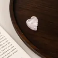 Close-up of a pearlescent white acetate heart hair claw clip on a dark wooden tray - 6# Dreamy Purple