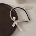 Detail of double-row pearl headband featuring ivory satin bows and long flowing ribbons - White