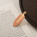 Macro detail of checkered acetate hair clip with golden metal clip on vintage book - Large / Orange White Plaid