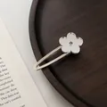 Detailansicht einer silbernen Haarspange mit Blumenmotiv auf einem Holztablett - Blume Seitenclip / Spiegel Silber