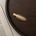Close-up of a vintage acetate hair clip with gold foil flakes on a wooden tray - Small / Transparent Gold Foil