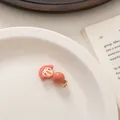 Detailansicht einer süßen Cartoon-Mädchen-Haarklammer mit Kunstharzperle auf Teller - Rosa Haar Rosa Perle