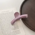 Primer plano detallado de una pinza para el pelo grande en color violeta mate sobre madera - Púrpura