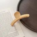 Detalle de una pinza para el pelo mate crema grande en una bandeja de madera - Amarillo Leche