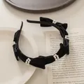 Detalle de diadema de terciopelo negro con anillos de perlas y lazos hechos a mano - Negro