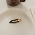 Detailansicht der französischen Vintage-Haarspange mit schwarzem Paneel auf einem weißen Teller - Schwarze Markierungsfreie Klammer