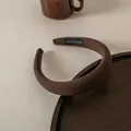 Detalle de la etiqueta tejida a mano en una diadema de esponja gruesa marrón café - Caqui Oscuro