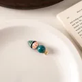 Detailed close-up of a cartoon figure hair clip with green striped hat and a teal bead - Hat Blue Bead