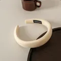 Detalle de diadema de esponja color crema con una etiqueta textil negra hecha a mano - Blanco Roto