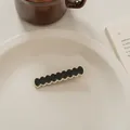 Detail eines schwarz-weißen Wellen-Haarclips im französischen Vintage-Stil auf Keramik - Round Wave-Black