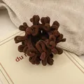 Gedetailleerd beeld van donkerbruine pluche haarelastiek met zachte chenille-textuur en elasticiteit - Chocolade Koffie