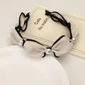 Detail view of beige fabric headband with black piping and elegant silver pearl accents - Beige