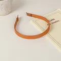 Detail shot of brown leather headband with fine stitching on a minimalist desk - 25# Stitched Edge Style