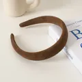Detailaufnahme des dicken kaffeebraunen Wildleder-Haarreifs auf minimalistischem Hintergrund - Dunkelkaffee