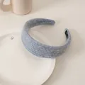 Detailed macro view of soft light blue knit headband with handmade woven label - Knitted Fabric Sky Blue