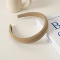 Detail eines khakifarbenen Wildleder-Haarreifens auf einem Buch mit Samtstruktur - Milchkaffee