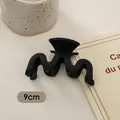 Detailansicht einer 9cm matt schwarzen Haarklammer mit Wellendesign auf hellem Grund - M-Form Welle (FJ259)