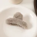 Detalle de una pinza para el cabello de piel sintética topo sobre una bandeja cerámica - Gris