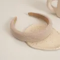 Close-up of beige corduroy padded headband texture on a minimalist ceramic tray - Beige