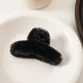 Primer plano de pinza para el cabello de felpa negra suave en una bandeja blanca - Negro